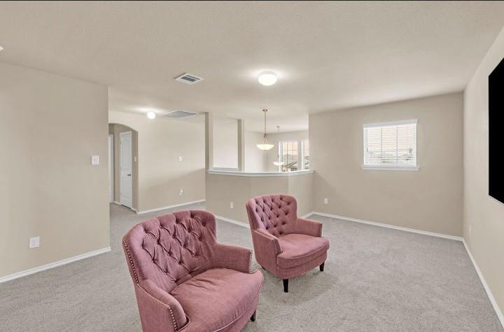 2315 Julia Lane Forney, TX 75126 - Photo 21 of 35 Living area with arched walkways, light carpet, and a textured ceiling