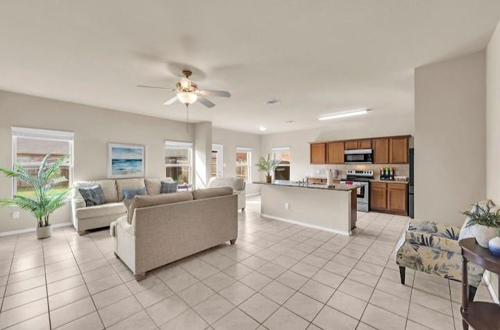 2315 Julia Lane Forney, TX 75126 - Photo 28 of 35 Living area featuring a ceiling fan, light tile patterned floors, and healthy amount of natural light