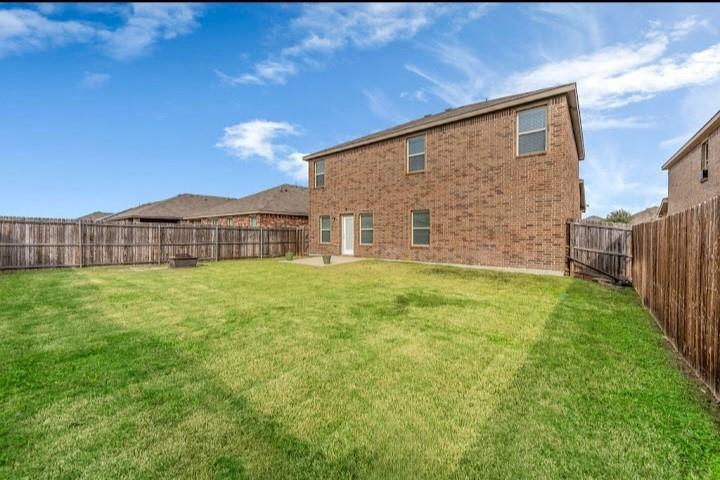 2315 Julia Lane Forney, TX 75126 - Photo 6 of 35 Back of house with brick siding, a patio area, and a fenced backyard