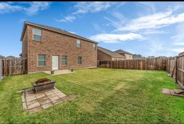 a backyard of a house with table and chairs