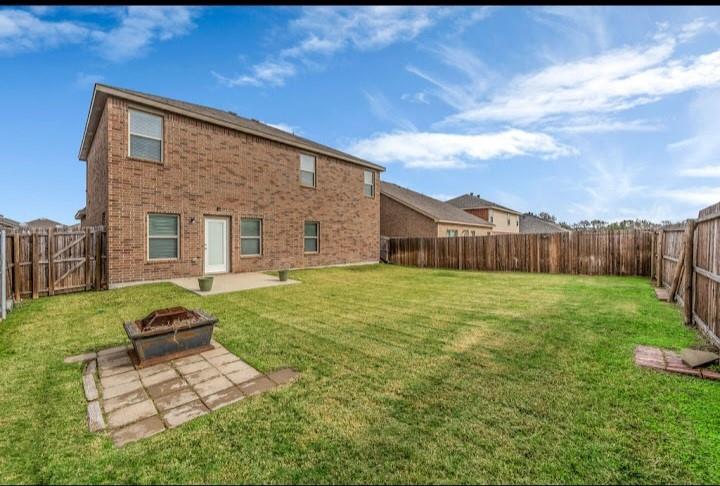 2315 Julia Lane Forney, TX 75126 - Photo 7 of 35 Rear view of property with a patio, brick siding, a fenced backyard, and an outdoor fire pit