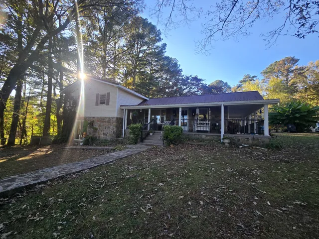 a view of a backyard with a barn and large trees