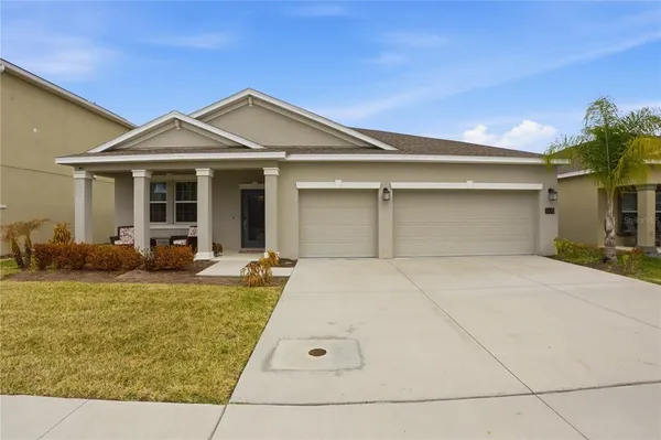 a view of a house with backyard and sitting area