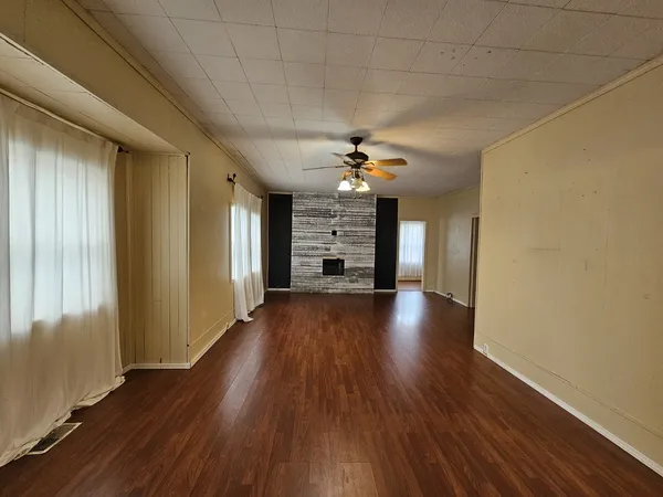 a view of a livingroom with wooden floor and a ceiling fan
