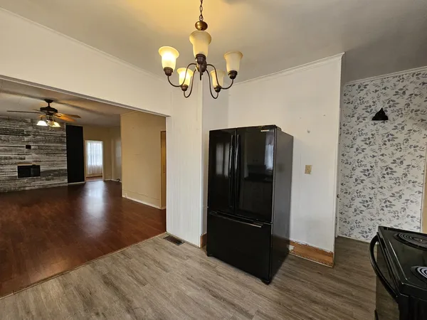 a view of a hallway with wooden floor and chandelier
