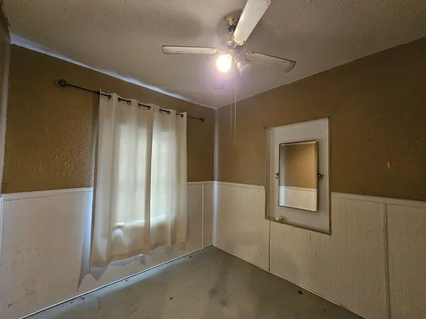 an empty room with closet and windows