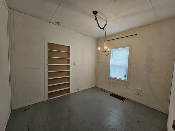 a view of empty room with ceiling fan and window
