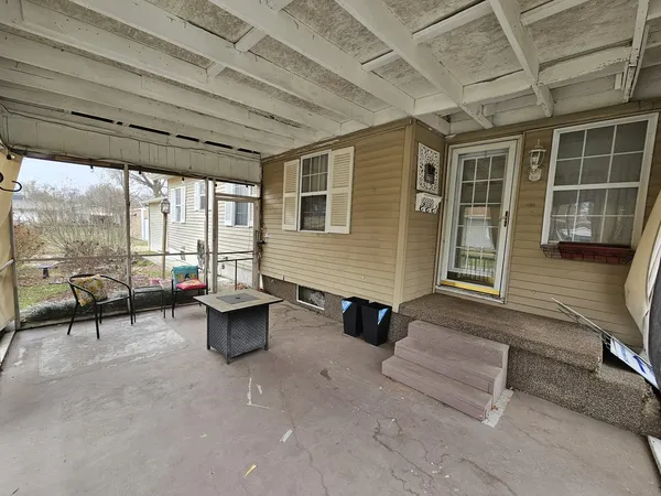 a view of a patio with couple of chairs and potted plants