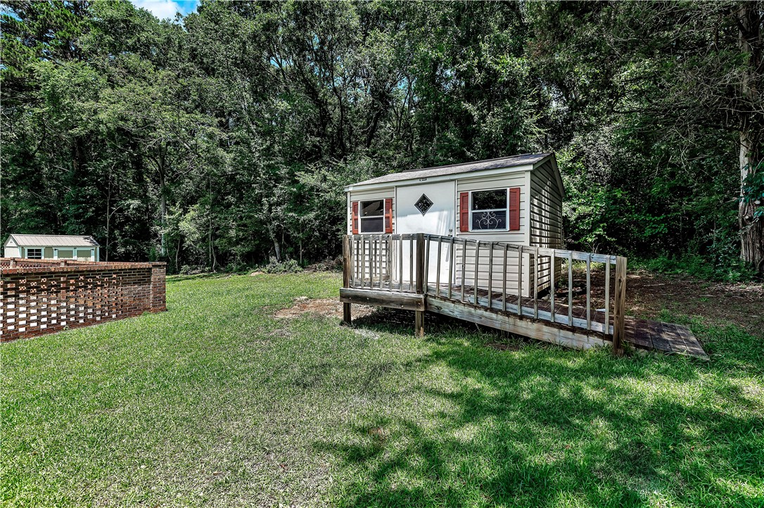 910 Chantilly Lane Anderson, SC 29625 - Photo 36 of 38 A quaint detached shed with a wooden ramp and surrounding greenery offers practical outdoor storage.