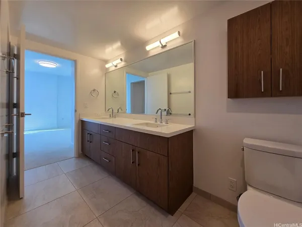 a bathroom with a double vanity sink toilet and shower