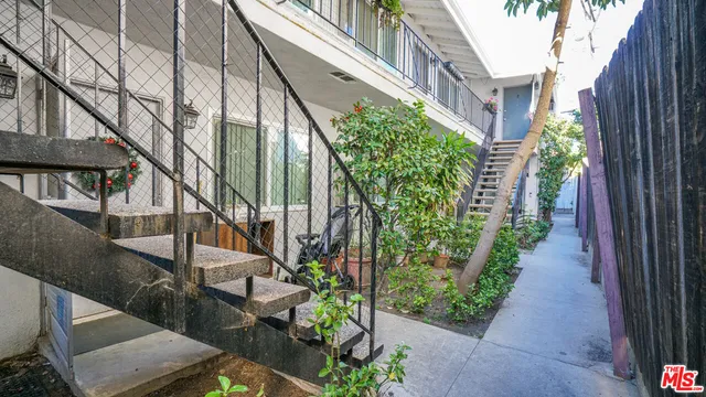 a view of a pathway of a house with potted plants