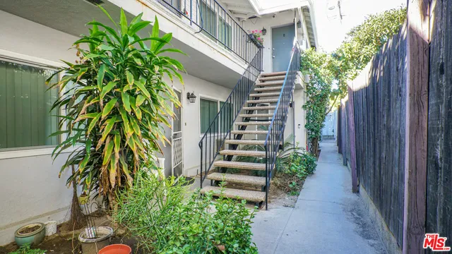 a porch with chairs and potted plants