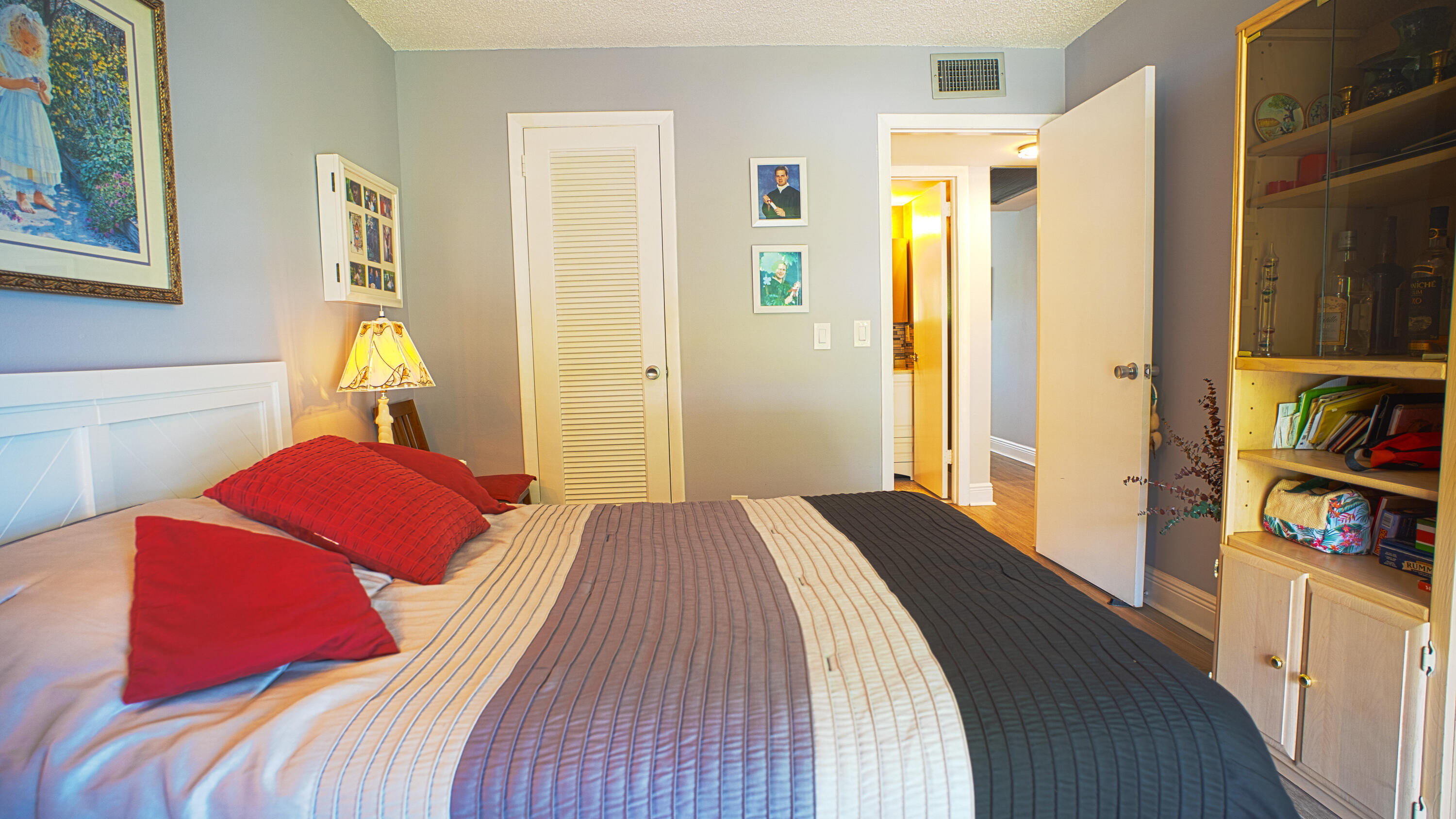 240 Windsor K West Palm Beach, FL 33417 - Photo 15 of 30 a bedroom with a bed and a book shelf