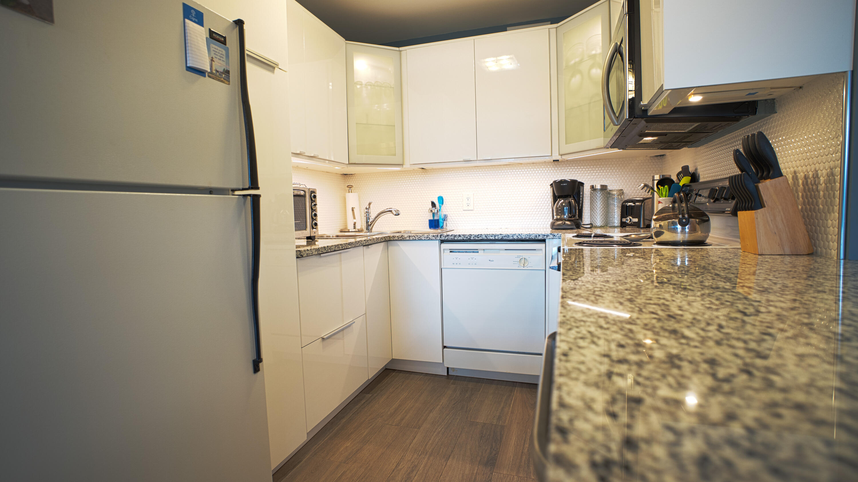240 Windsor K West Palm Beach, FL 33417 - Photo 6 of 30 a kitchen with a refrigerator and white cabinets
