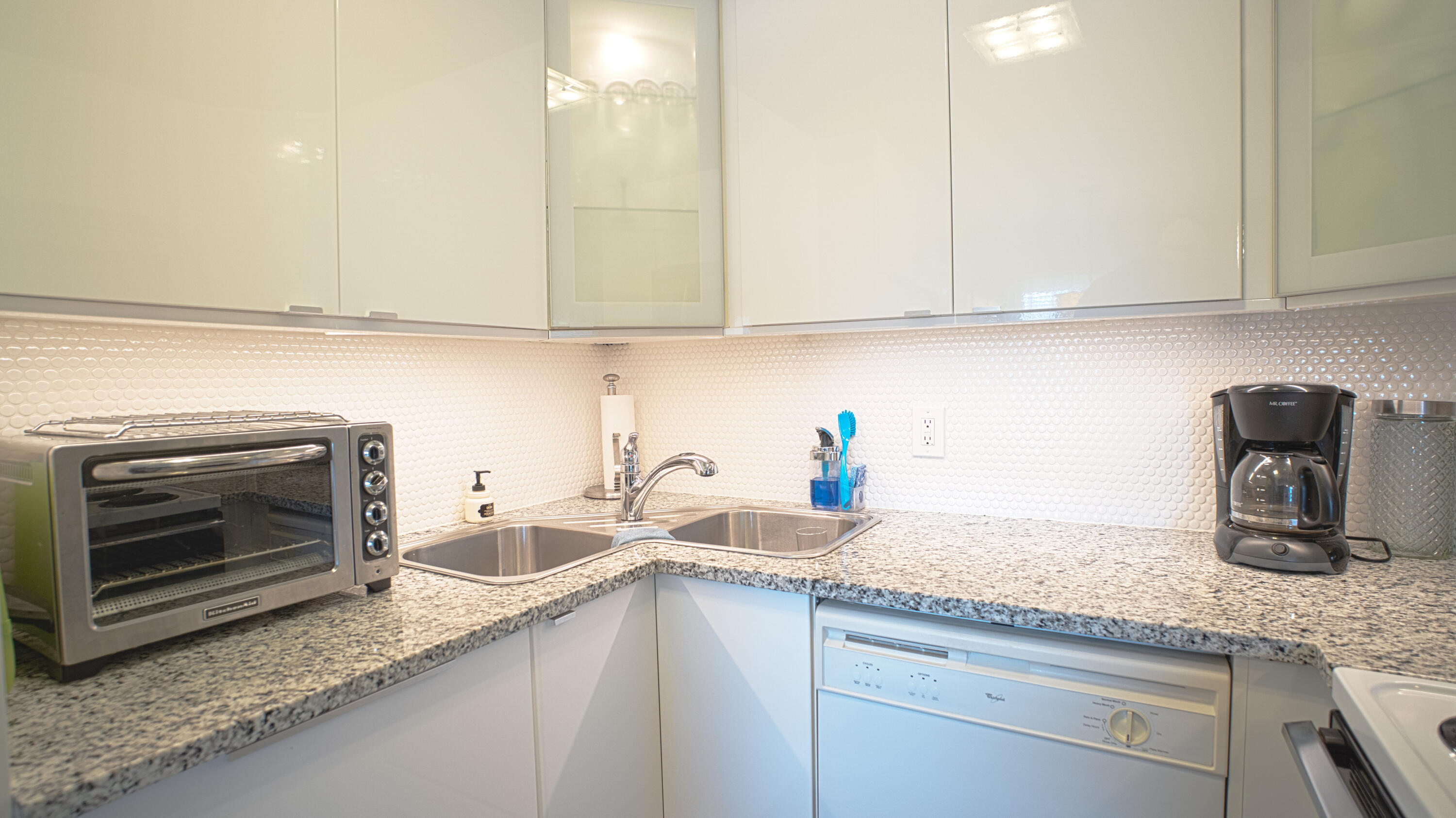 240 Windsor K West Palm Beach, FL 33417 - Photo 7 of 30 a kitchen with granite countertop a sink a stove and cabinets
