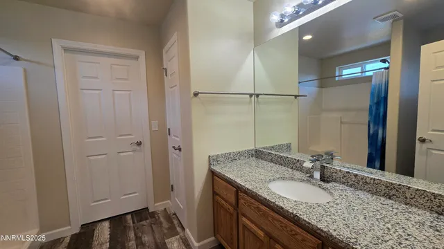 a bathroom with a granite countertop sink and a mirror