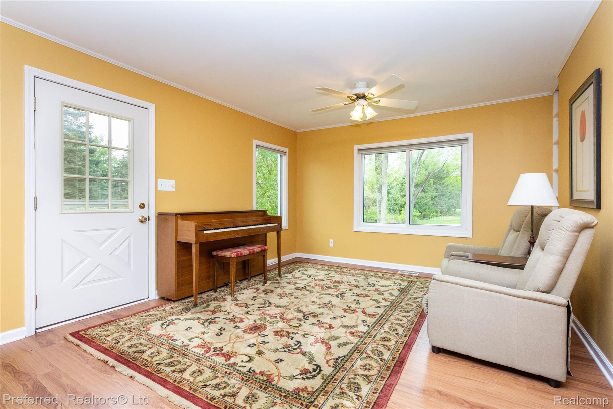 9840 Currie Road Northville, MI 48167 - Photo 10 of 62 Sitting room featuring light wood finished floors, healthy amount of natural light, ornamental molding, and a ceiling fan