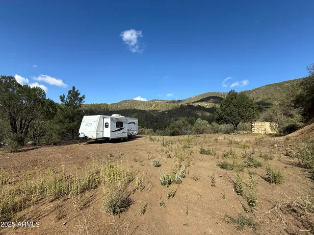 a view of a dry yard with mountains in the background