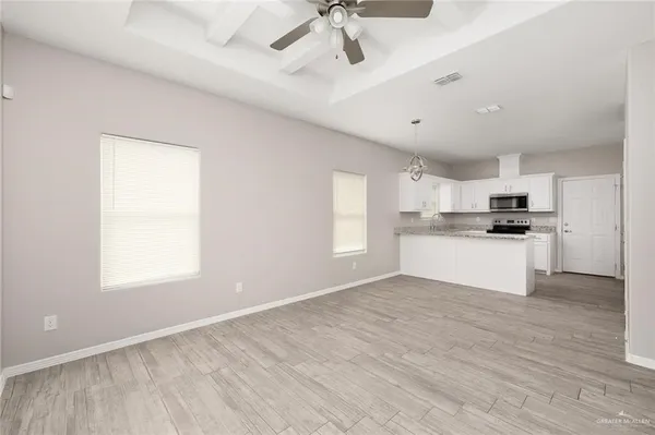 a view of kitchen with granite countertop stainless steel appliances cabinets a sink and a window