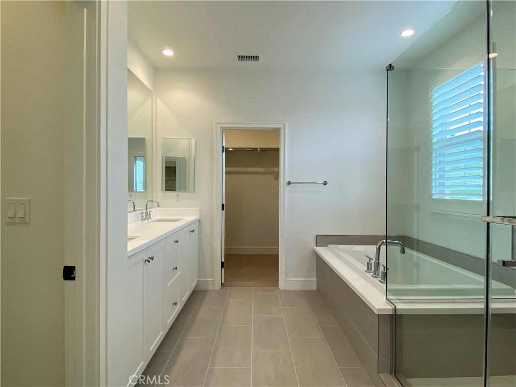 120 Spotted Quail Irvine, CA 92618 - Photo 17 of 32 a bathroom with a tub sink shower and mirror
