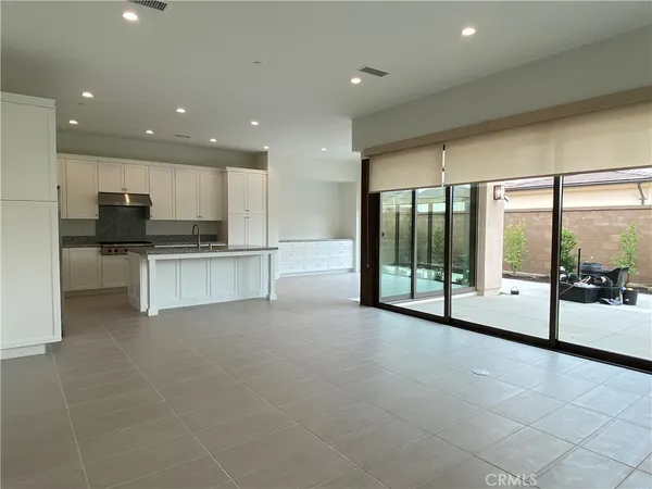a large white kitchen with a large window and stainless steel appliances