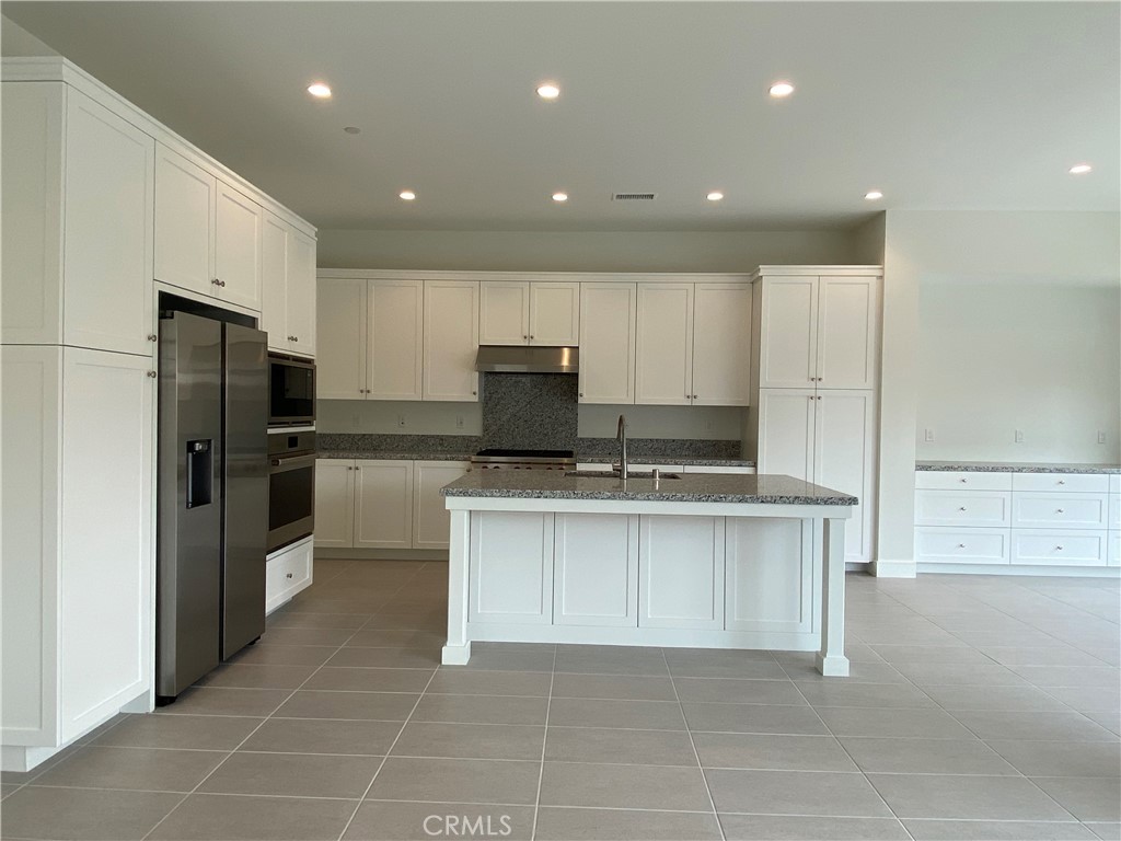 120 Spotted Quail Irvine, CA 92618 - Photo 4 of 32 a large kitchen with a large counter top stainless steel appliances and cabinets
