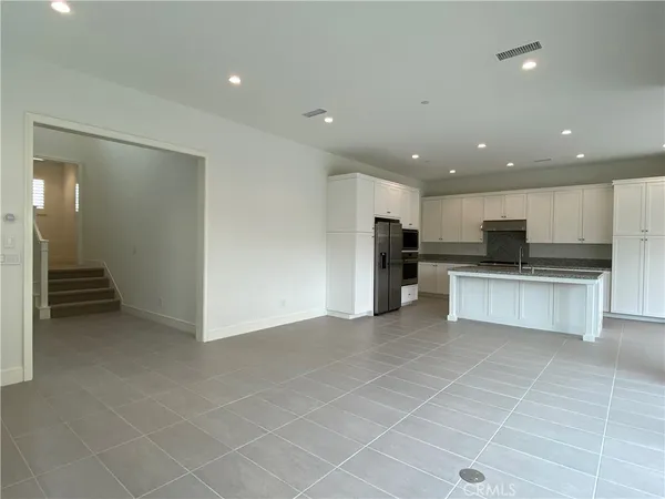 a view of kitchen with refrigerator and microwave