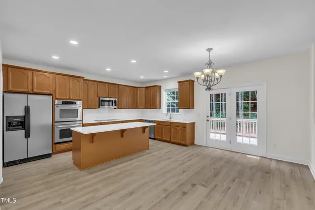 a large kitchen with stainless steel appliances wooden floors and large cabinets
