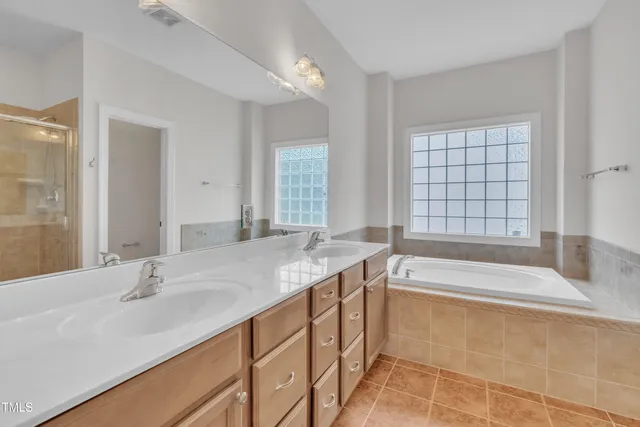 a bathroom with a granite countertop tub sink and mirror