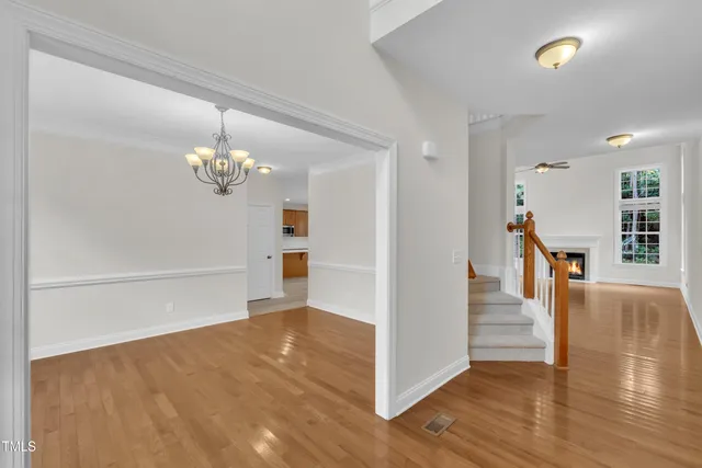 a view of a room with wooden floor staircase and a kitchen