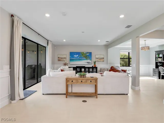 a living room with furniture a flat screen tv and a large window