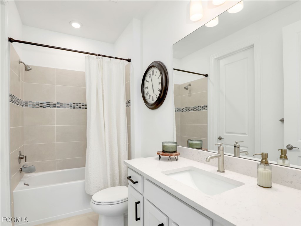 20179 Napa Loop Estero, FL 33928 - Photo 21 of 49 a bathroom with a bathtub shower sink vanity mirror and toilet
