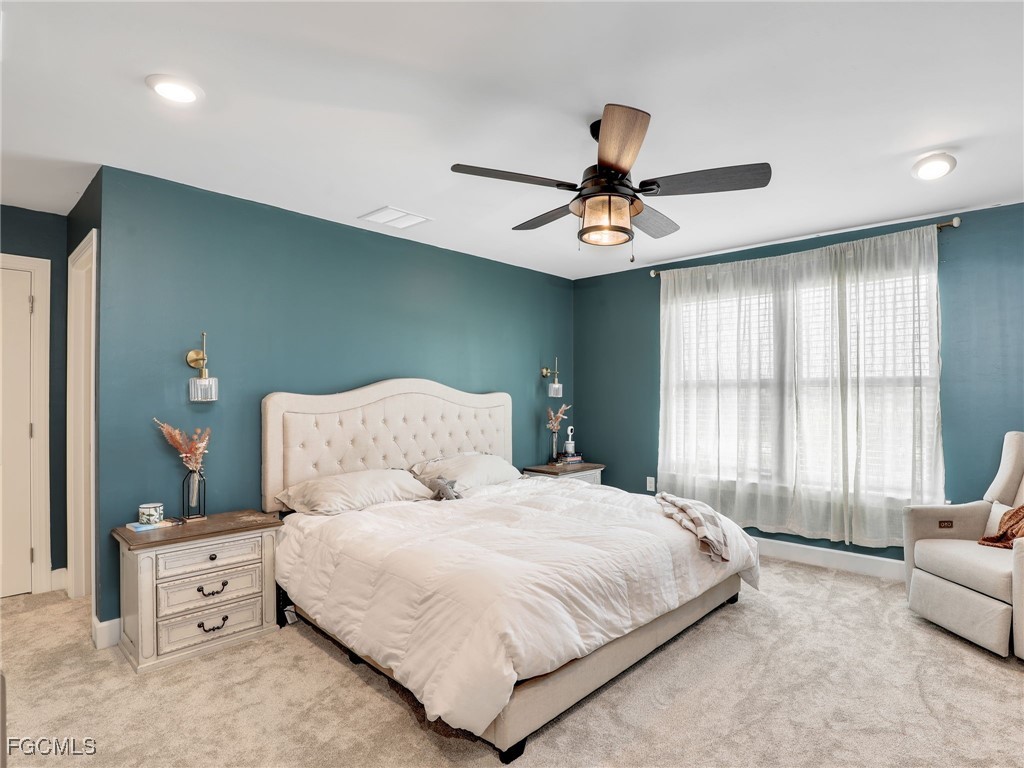 20179 Napa Loop Estero, FL 33928 - Photo 23 of 49 a bedroom with a large bed and a chandelier