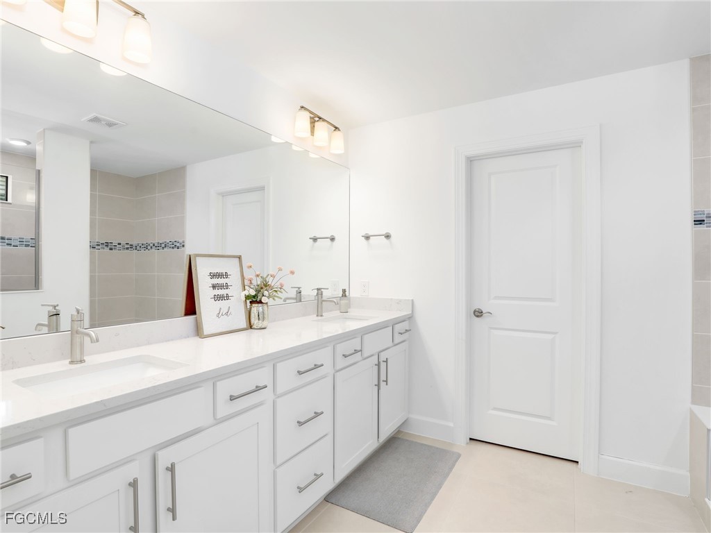 20179 Napa Loop Estero, FL 33928 - Photo 25 of 49 a spacious bathroom with a double vanity sink and a mirror