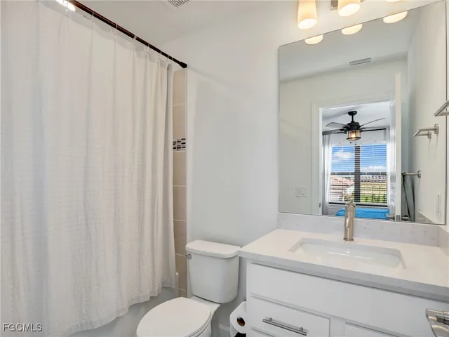 a bathroom with a sink a toilet and shower curtain