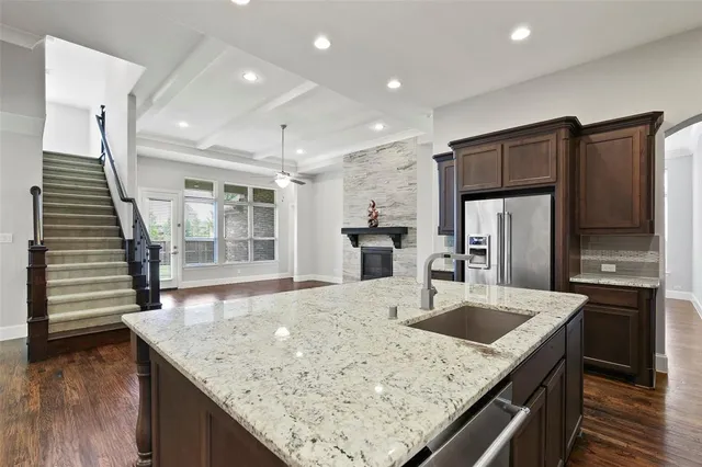 a kitchen with stainless steel appliances granite countertop a sink and a refrigerator