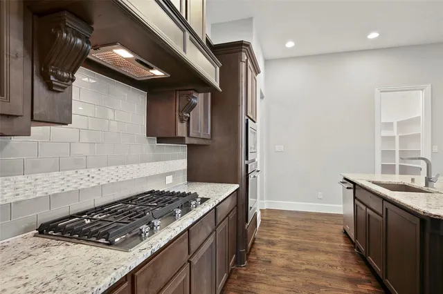 a kitchen with stainless steel appliances granite countertop a stove and a refrigerator