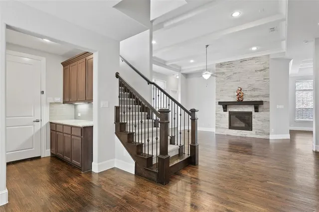 an entryway with staircase and a kitchen space with a sink