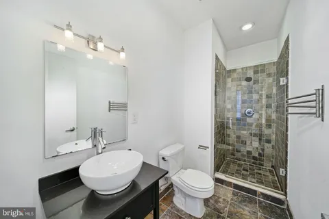 a bathroom with a sink toilet a mirror and shower