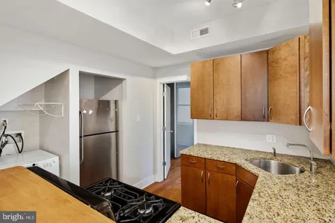 a kitchen with granite countertop a refrigerator and a sink