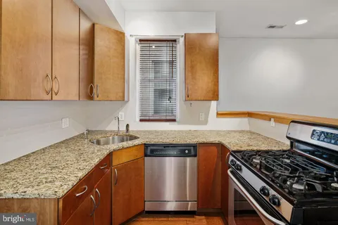 a kitchen with granite countertop a sink and a stove