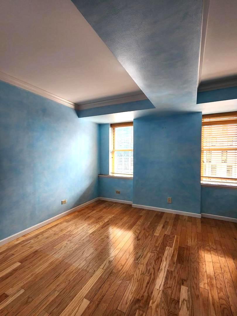 40 East 9th Street, Unit 1604 Chicago, IL 60605 - Photo 13 of 25 an empty room with wooden floor and windows