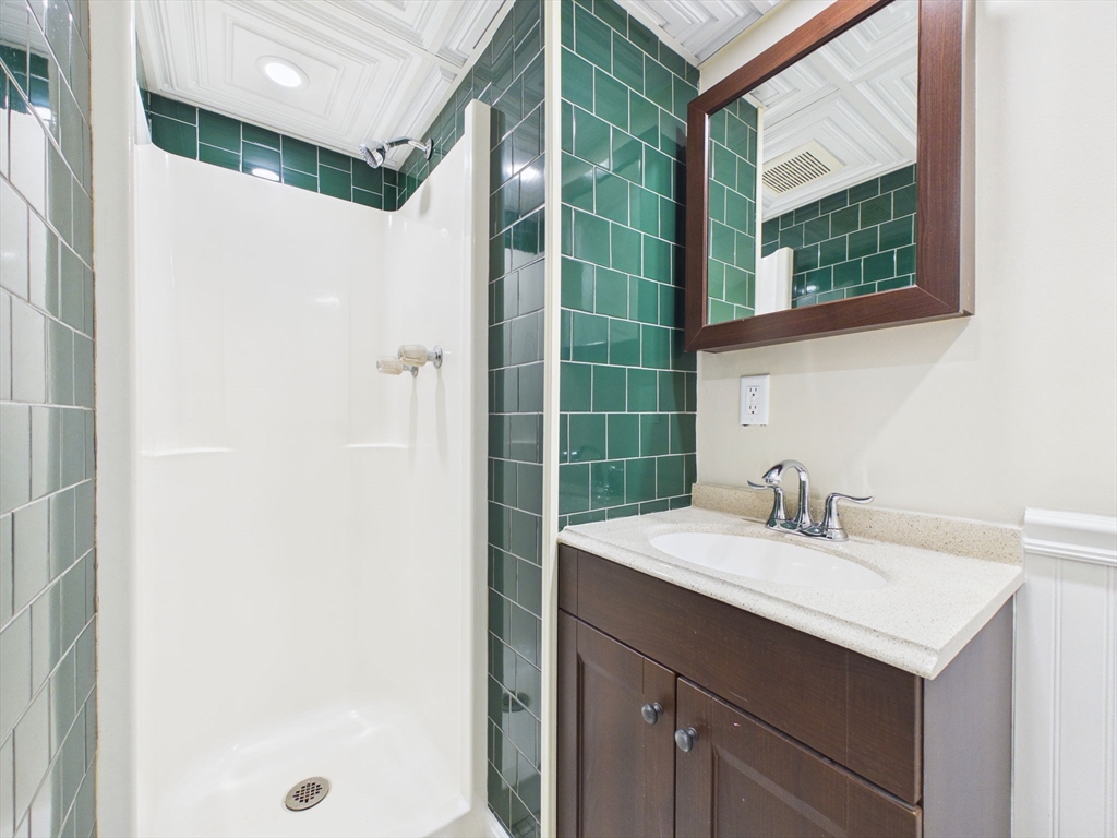 786 Wildwood Road New Bedford, MA 02745 - Photo 30 of 39 a bathroom with a sink a mirror and a shower