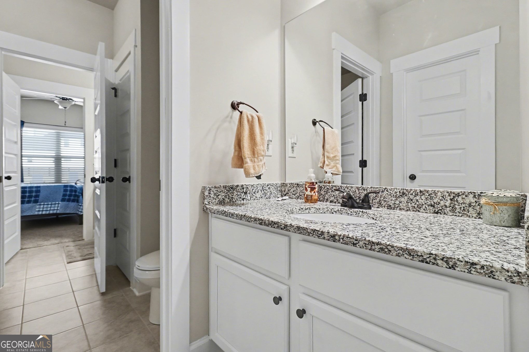 9 Union Street Newnan, GA 30263 - Photo 28 of 31 a bathroom with a granite countertop sink and a mirror