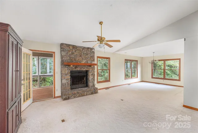 a view of an empty room with a fireplace and a window