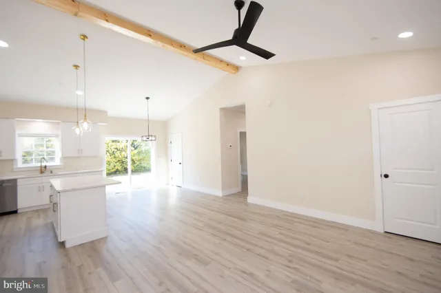 a view of kitchen with stainless steel appliances kitchen island wooden floor and window
