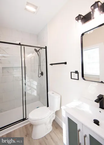 a view of a room with wooden floor and a ceiling fan