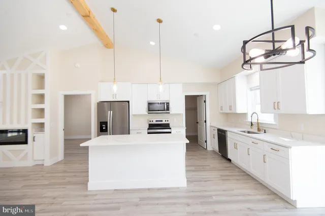 a large kitchen with stainless steel appliances kitchen island granite countertop a stove a sink a refrigerator and a refrigerator