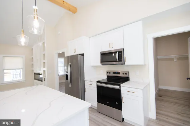 a kitchen with a refrigerator a sink and wooden floor