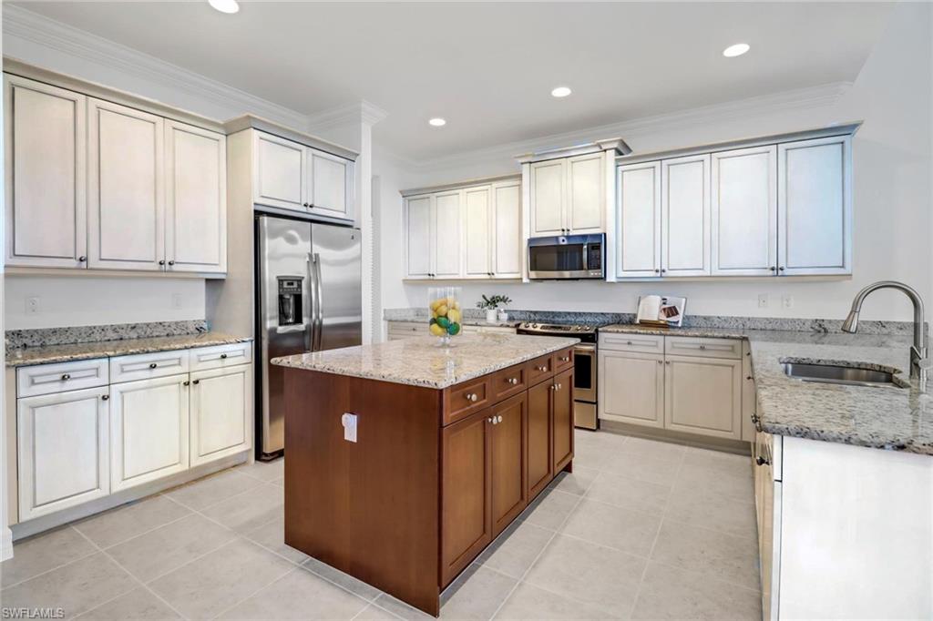 3260 Atlantic Circle Naples, FL 34119 - Photo 12 of 50 a kitchen with stainless steel appliances granite countertop a stove top oven a refrigerator a sink and dishwasher with white cabinets